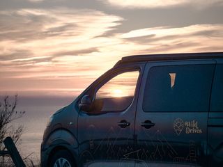 Eve on a cliff top, in front of a sunset