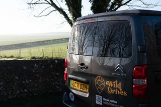 A stationary shot of the back of Eve the campervan, with rolling hills in the background