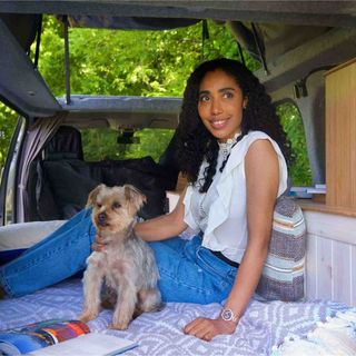 A woman and her dog pear out of the van