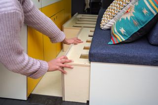 A woman pulling out the slats to make a bed