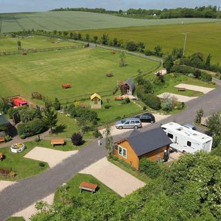 The stonehenge campsite. In the backgroun there are big expansive fields and woodland